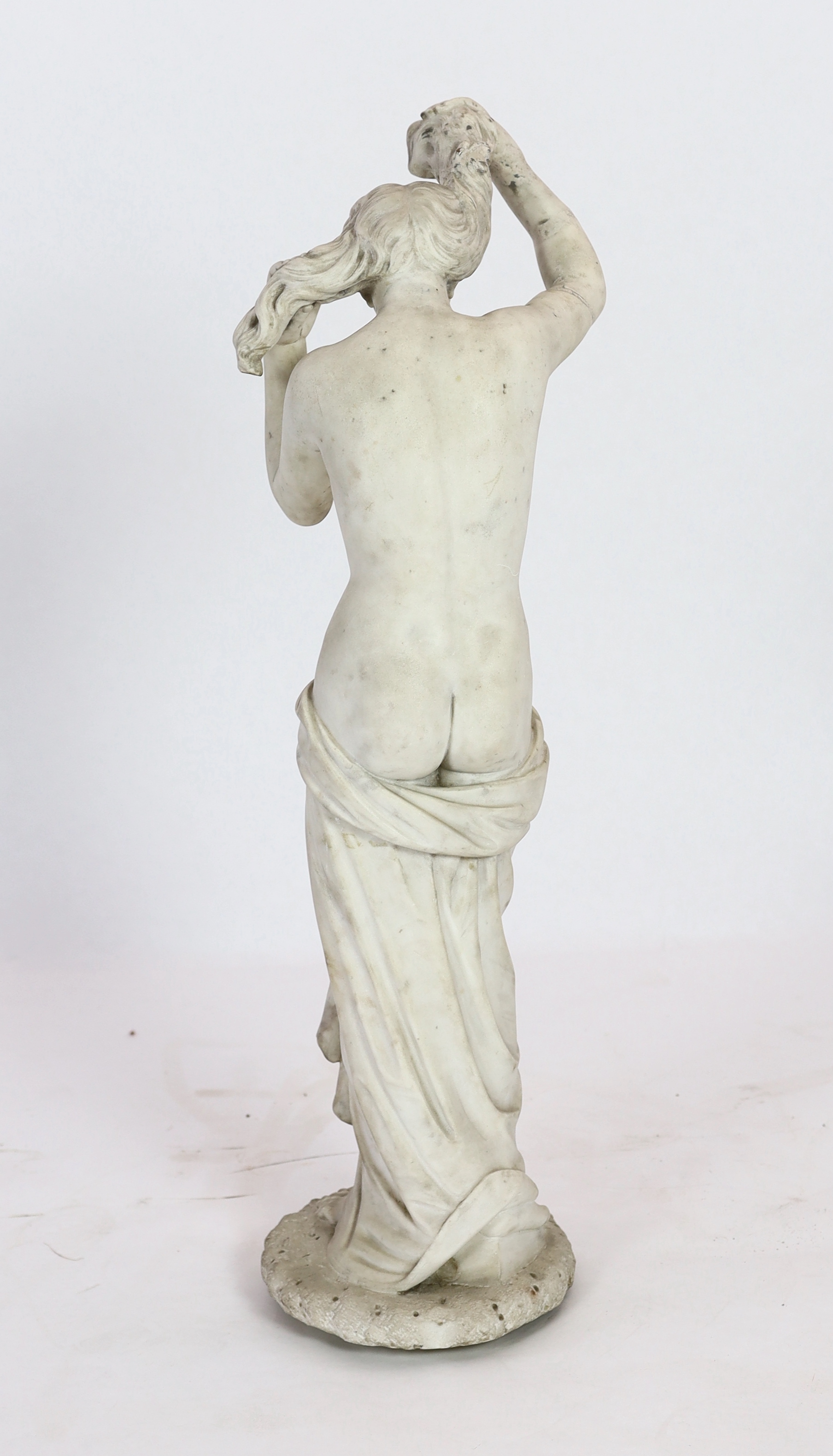 After the Antique. A late 19th century Italian carved white marble figure of Venus Anadyomene